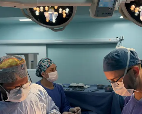 Equipe de cirurgia operando no centro cirúrgico, de touca e máscara